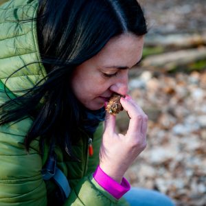 Waldbaden: Frau riecht an Zapfen