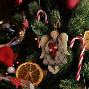 Weihnachtsbaumzweige mit Engel, Zuckerstange und Orangenscheibe