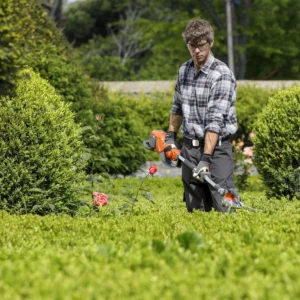 Mann pflegt Grünanlage