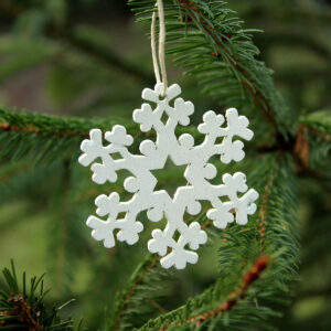 Weihnachtsbäume in anderen Ländern: Holz-Schneeflocke am Fichtenzweig