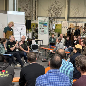 Menschen in Diskussionsrunde zum Thema Obstbaumpflege