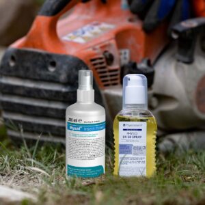 UV-Schutzmittel und Insektenschutzmittel auf dem Boden vor einer Motorsäge. © Peter Greven Physioderm GmbH